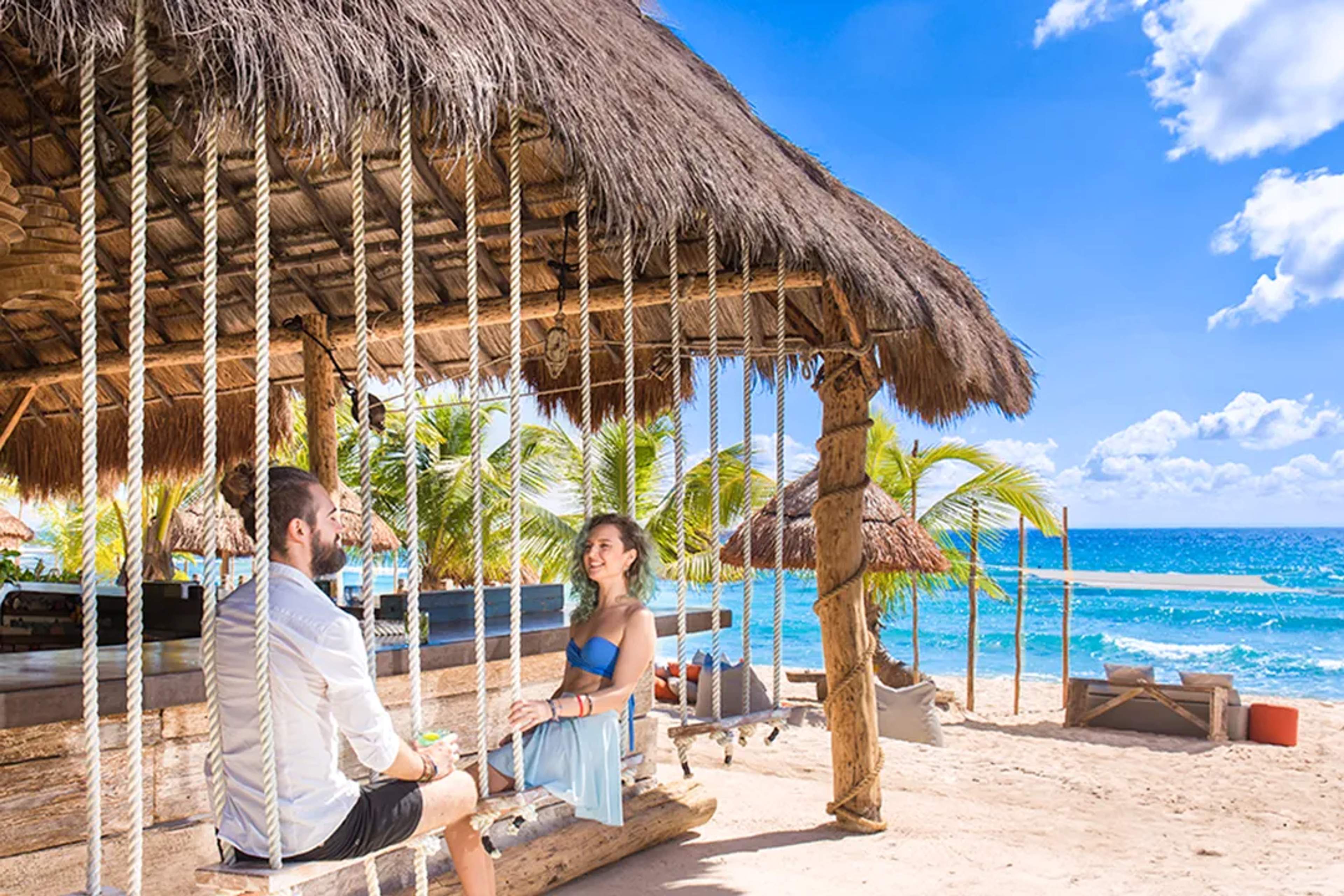 Luxury beach club with oceanfront loungers, swimming pools, bars, and vibrant social atmosphere perfect for seaside relaxation